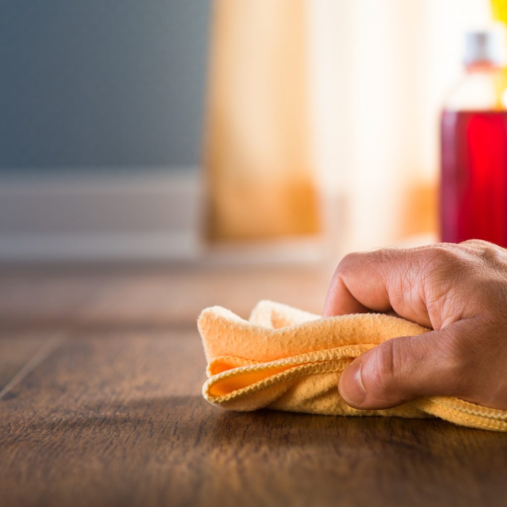 person staining hardwood floors