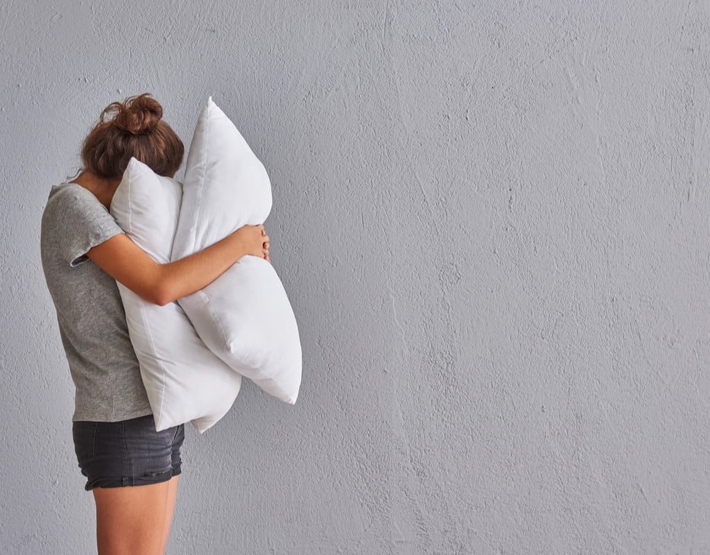 Woman hugs pillows