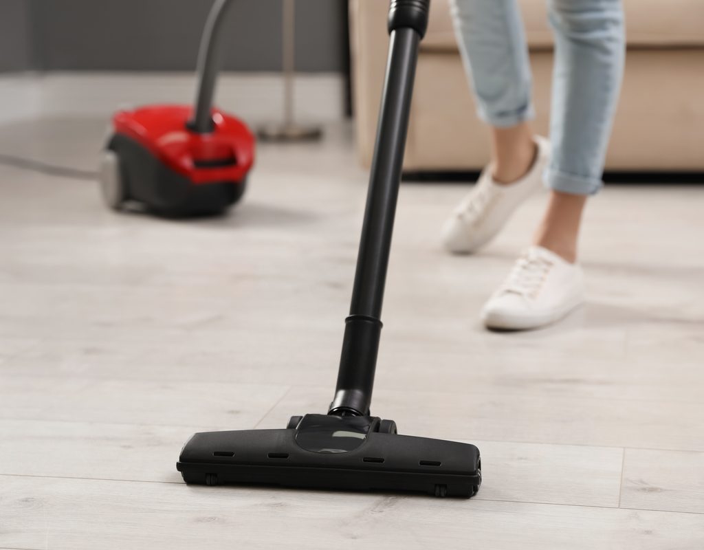 A woman vacuuming a hardwood floor