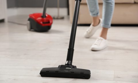 A woman vacuuming a hardwood floor