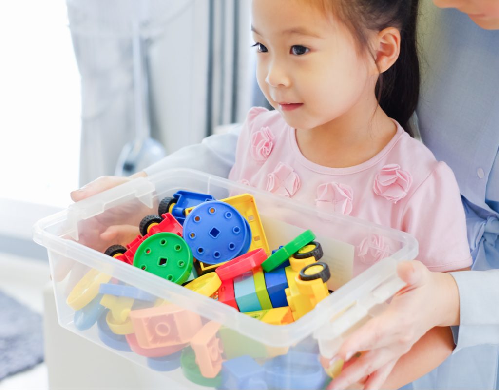 Small child holding box of toys
