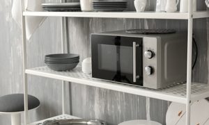Microwave on a shelf with dishes