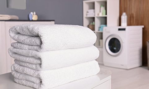 Three white towels folded in a modern laundry room