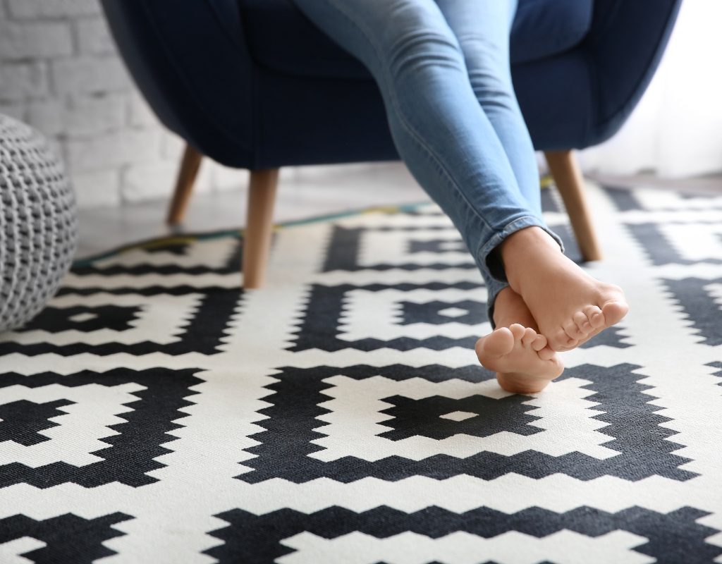 feet resting on black and white vinyl tile floor