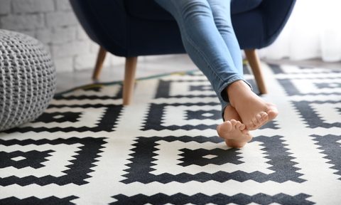 feet resting on black and white vinyl tile floor