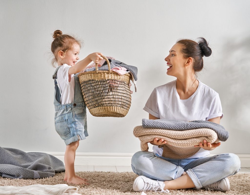 child helping her mother with laundry