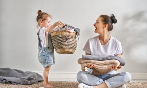 Child helping her mother with laundry