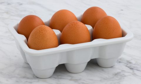 Hard-boiled eggs in a carton atop a marble counter