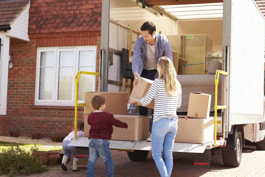 family putting boxes in moving truck