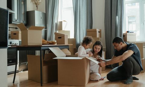 family packing boxes in living room