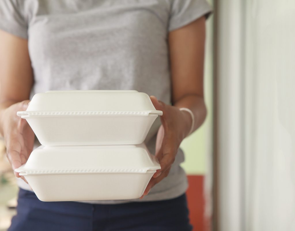 Person holding two Styrofoam carry-out containers