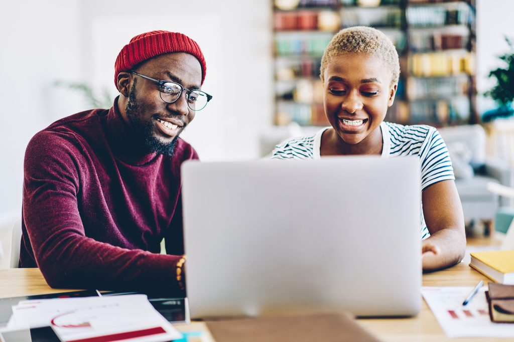 man and woman sitting at laptop