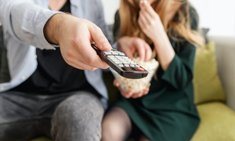 Couple holding a TV remote