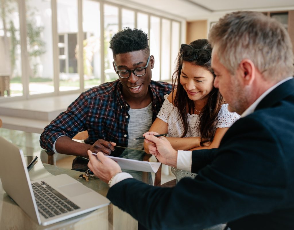 young couple talking with a real estate agent