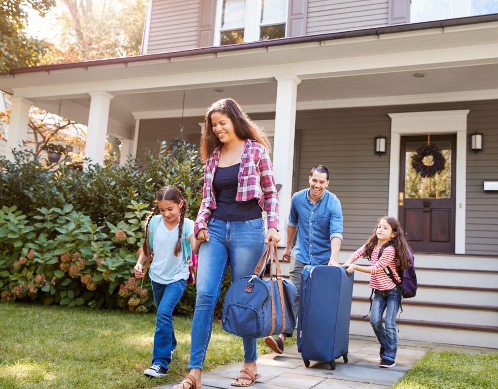 family carrying luggage and leaving home