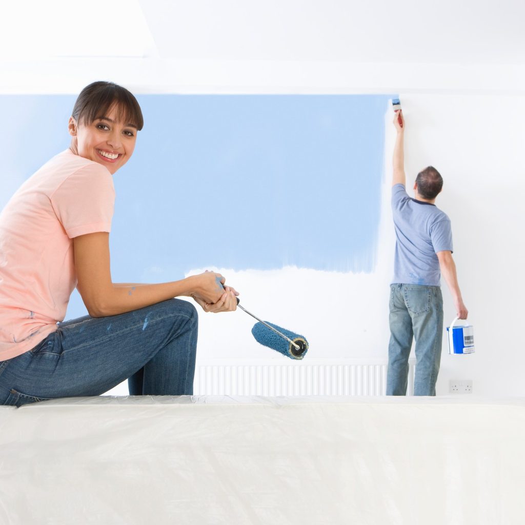 man and woman painting a room