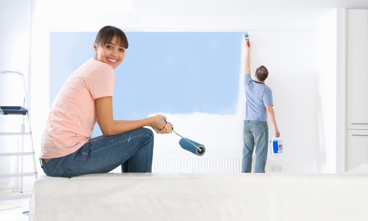 man and woman painting a room