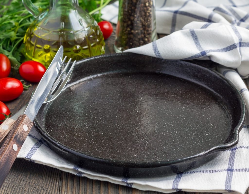 cast iron pan on table near vegetable oil
