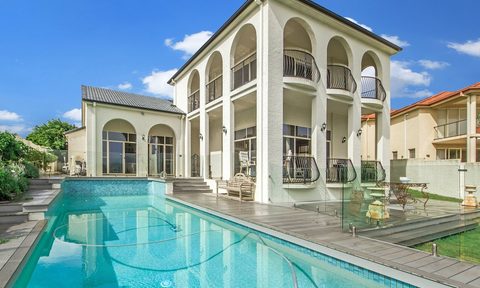 Outdoor inground pool with white two story home