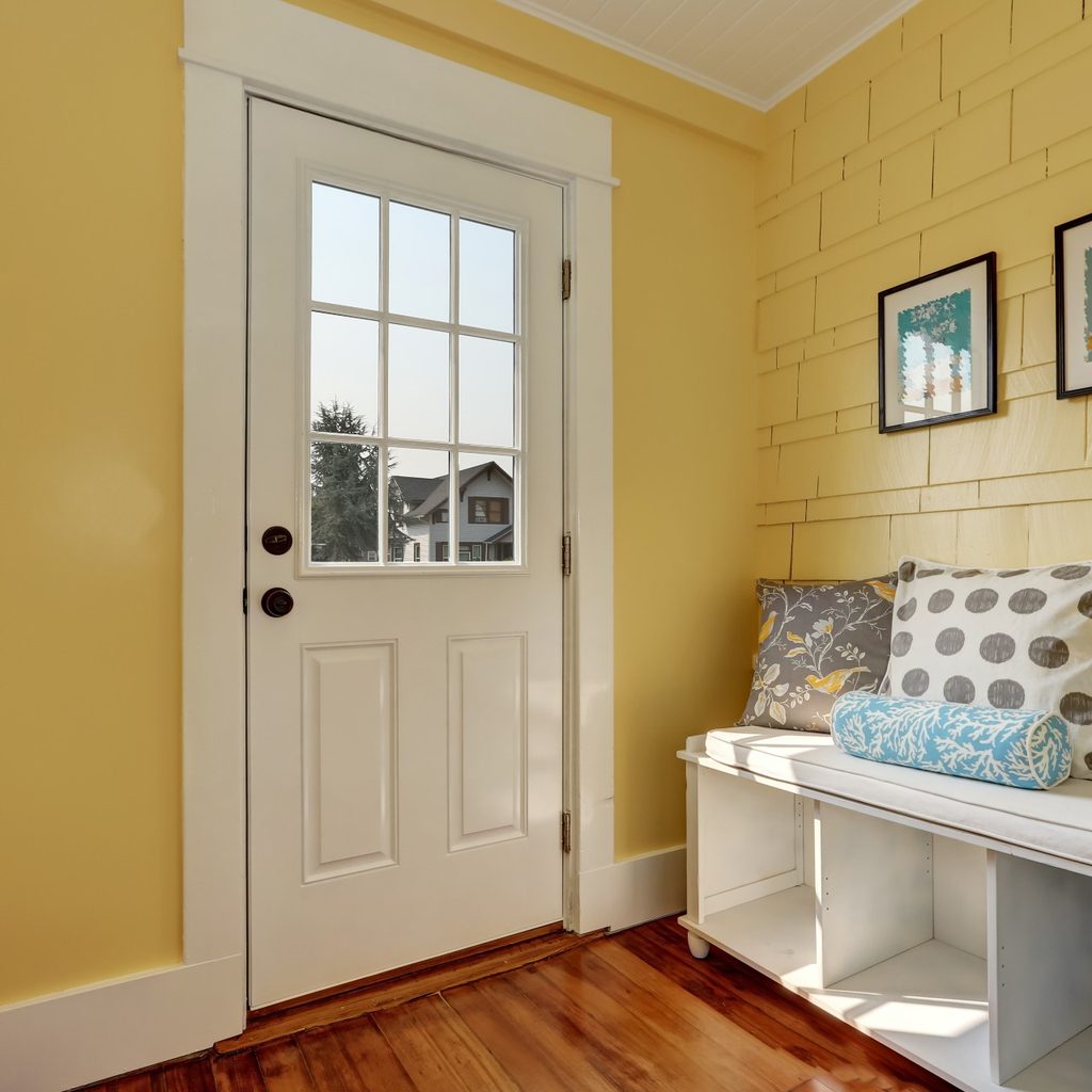 yellow entryway with bench