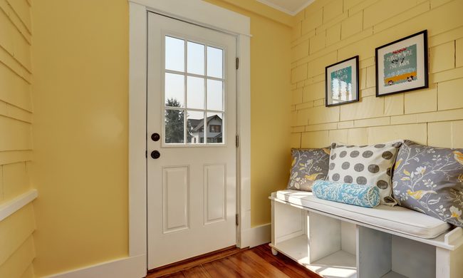 Butter yellow entryway with bench