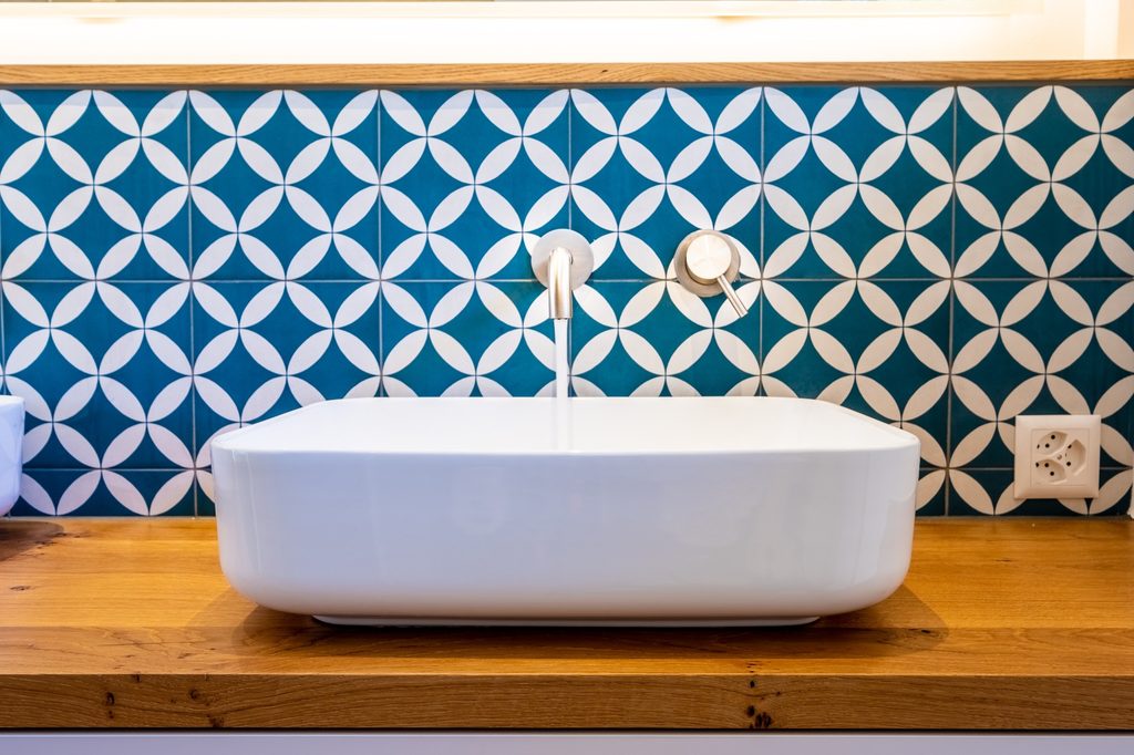 Blue and white tile behind the bathroom sink