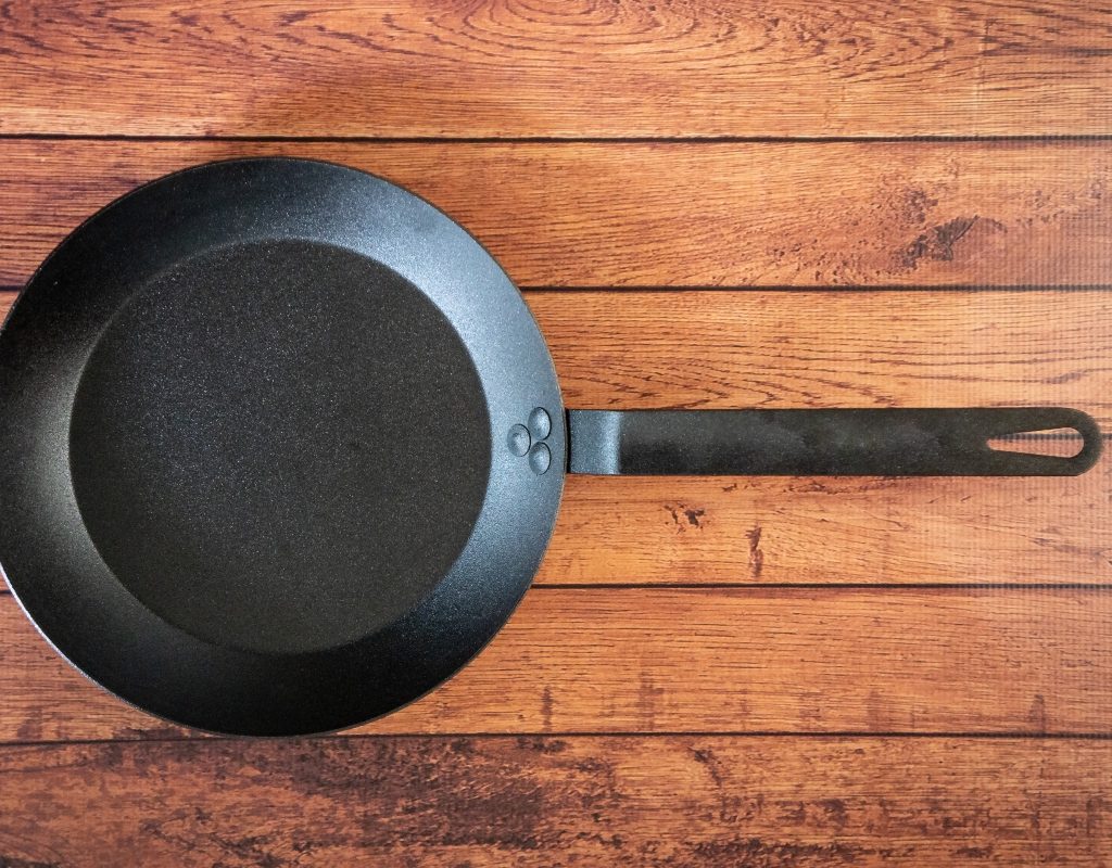carbon steel frying pan on wood table