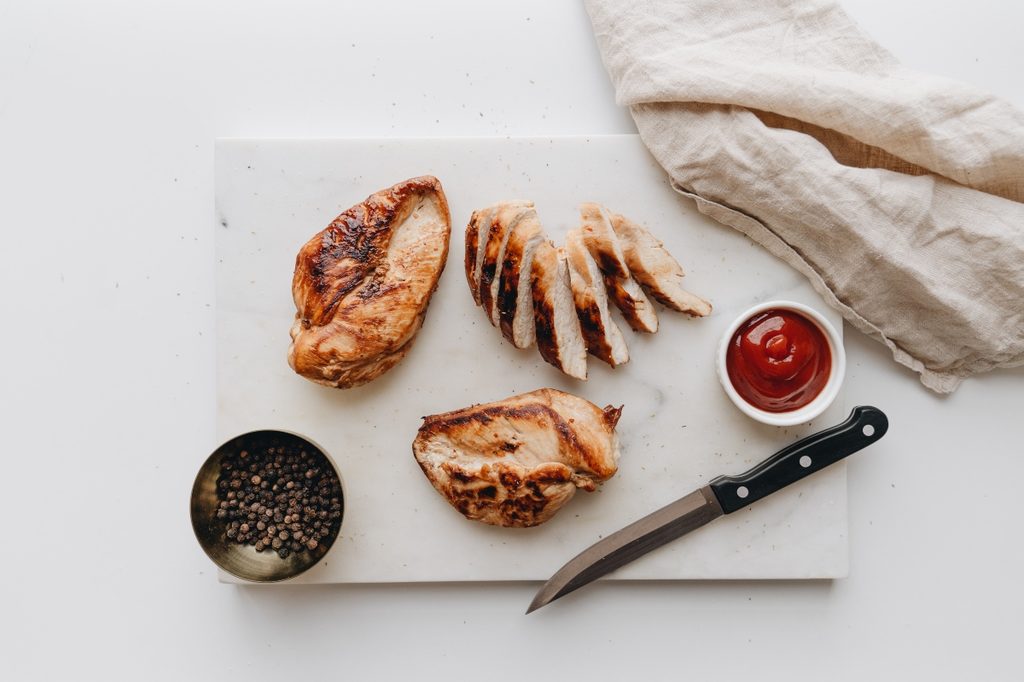 cut chicken breast on counter with knife