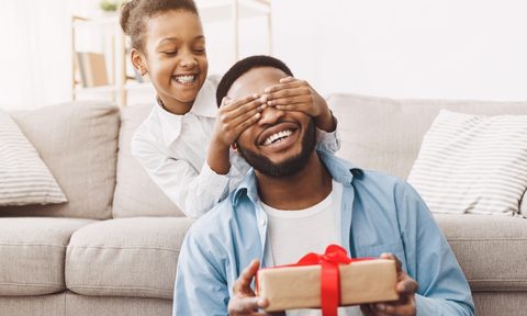 Girl surprising her dad with a Father's Day gift