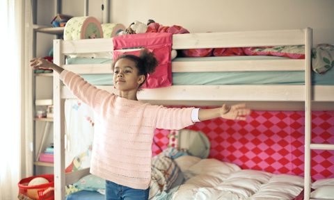 little girl standing in front of bunkbed