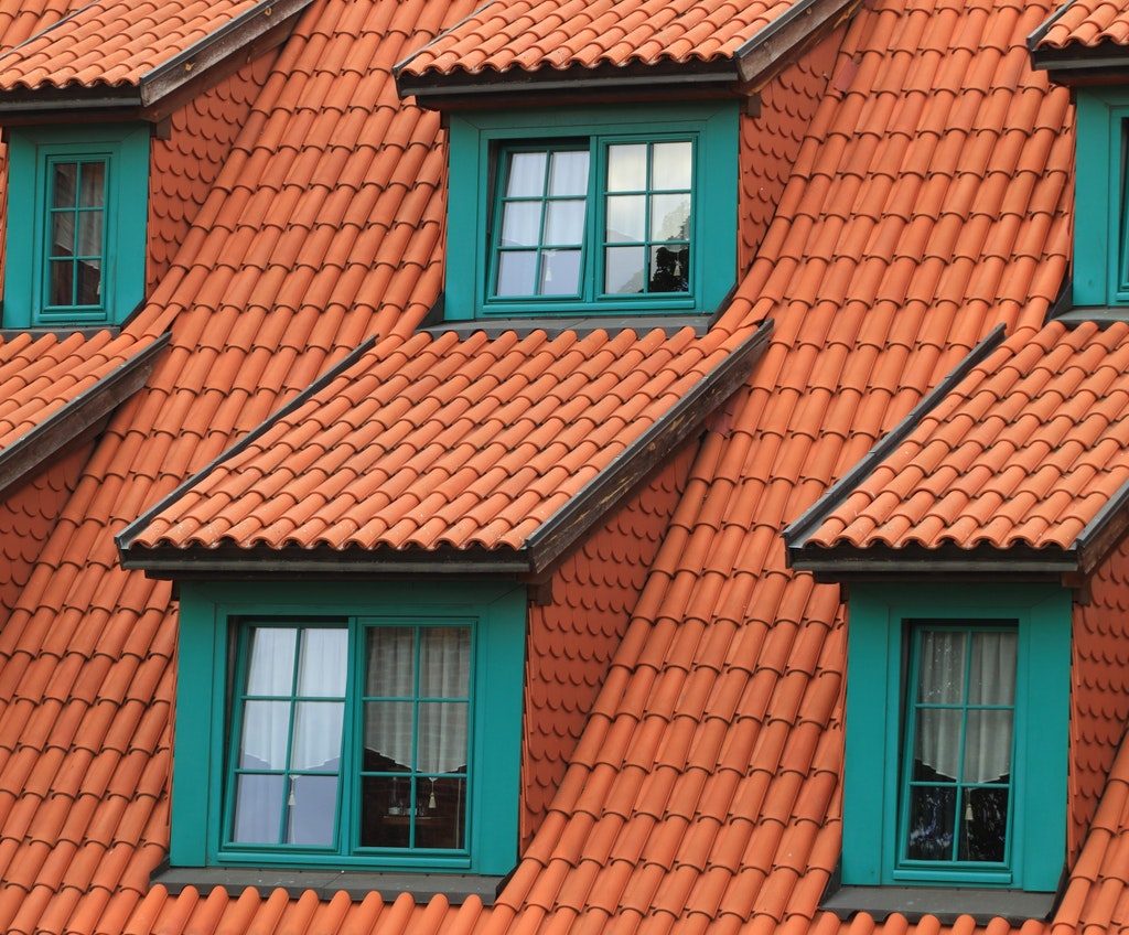 Roof with red shingles and multiple windows
