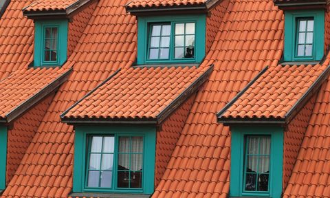 Roof with red shingles and multiple windows