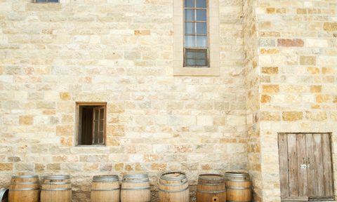 Wine barrels lined up in front of a building.