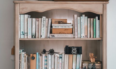 Vintage suitcases displayed on top of a shelving unit.