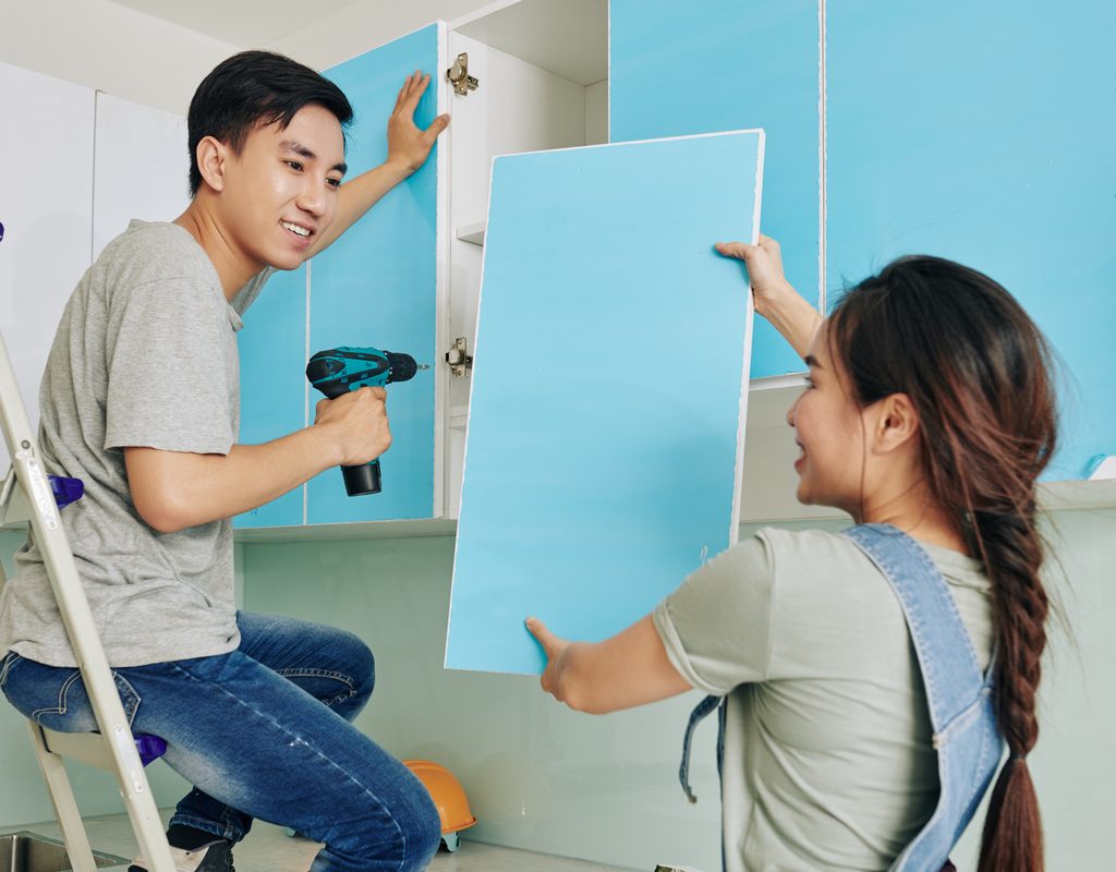 man and woman removing a cabinet door