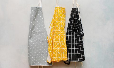three aprons hanging up on the wall