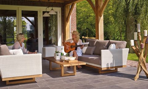Two women on the patio with one playing the guitar