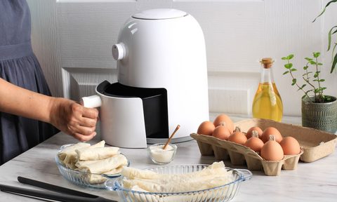woman opening white air fryer