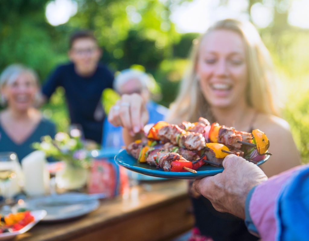 woman getting kababs at a dinner party