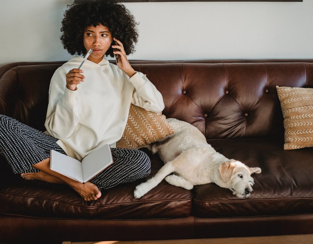 person with their pet on the leather couch