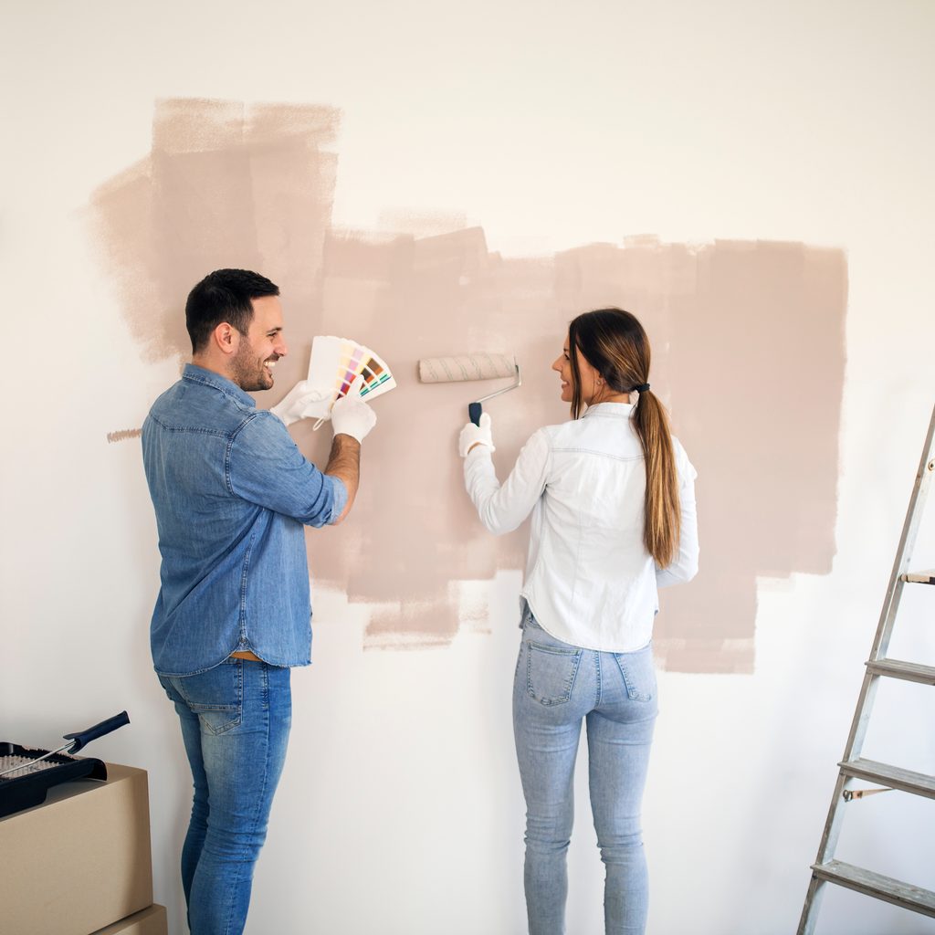 Couple Painting Neutral Colors On Wall