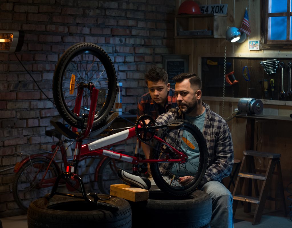 Dad and son working on a bike in the garage
