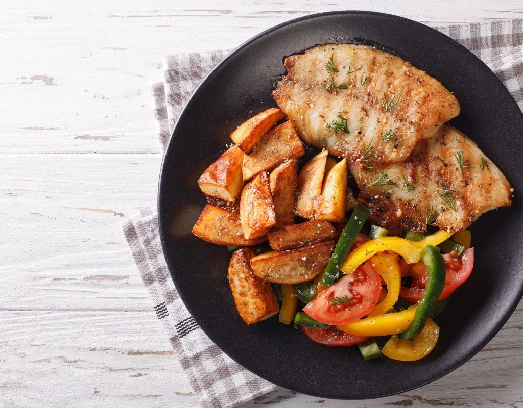 grilled tilapia and sides on a dish