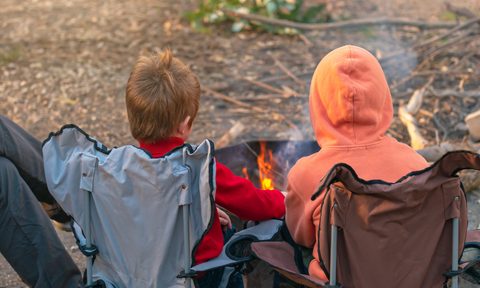 two kids by a fire pit