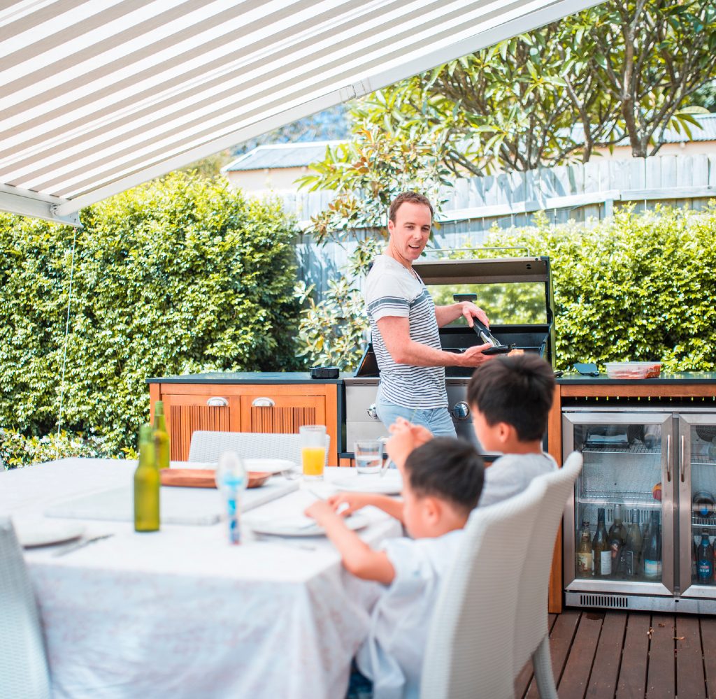 Dad and kids in covered outdoor kitchen area