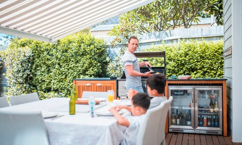 Dad and kids in covered outdoor kitchen area