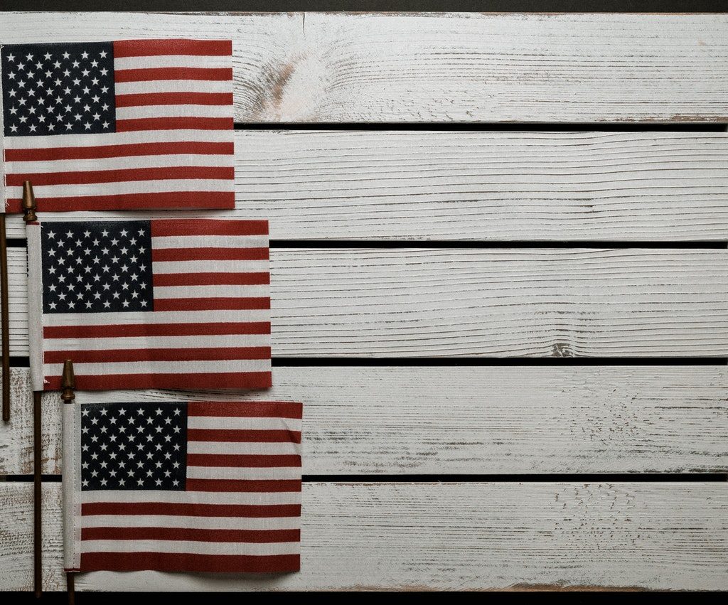 Three American flags on whitewashed wood