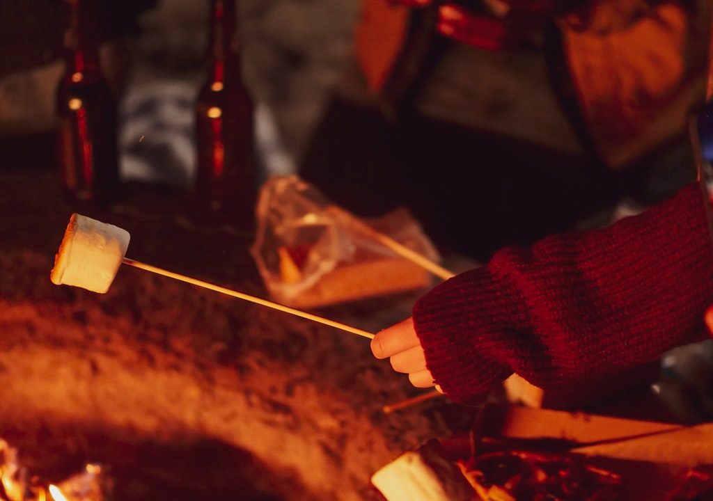 Roasting s'mores around a campfire
