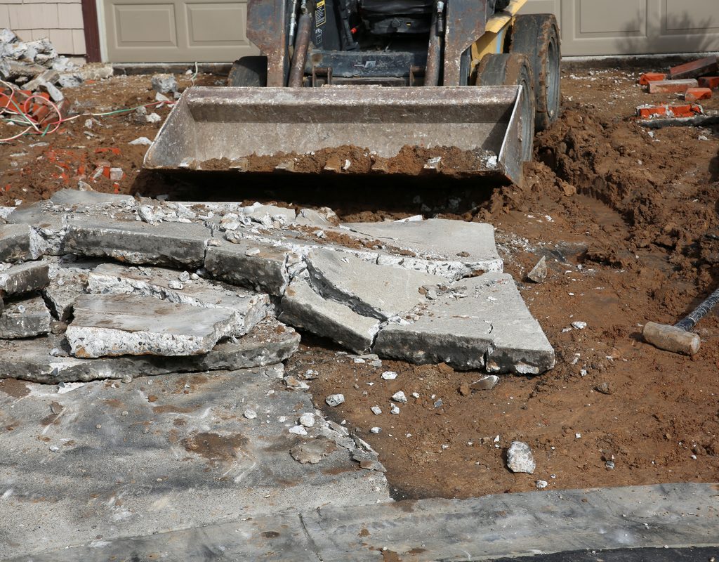 skid loader removing broken concrete slabs