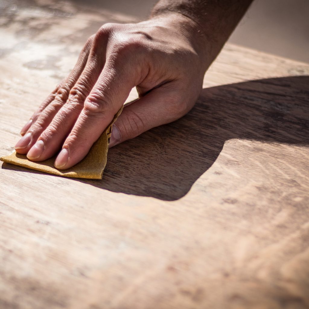 Man's Hand Holding Sandpaper